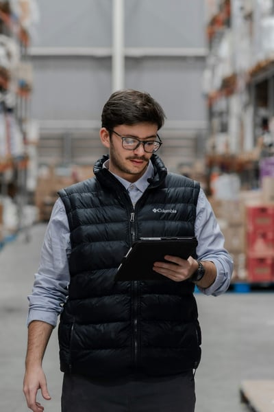 Supervisor reviewing a cleaning inspection on a tablet in a warehouse aisle Supervisor reviewing a cleaning inspection on a tablet in a warehouse aisle
