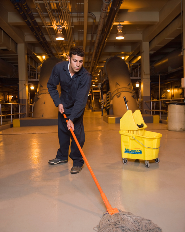 Janitor mopping in industrial setting